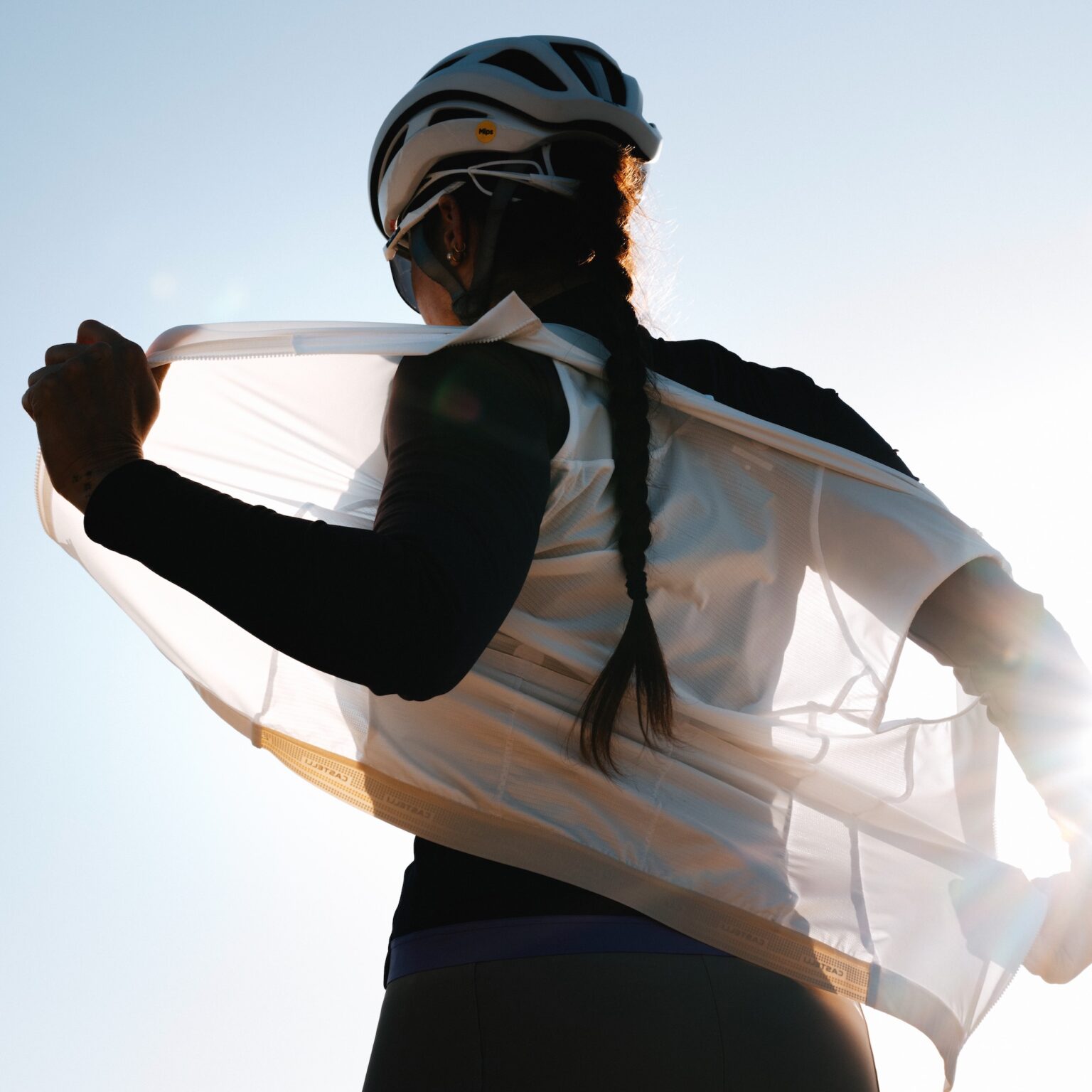 a woman putting on the castelli Espresso 2 Vest.
