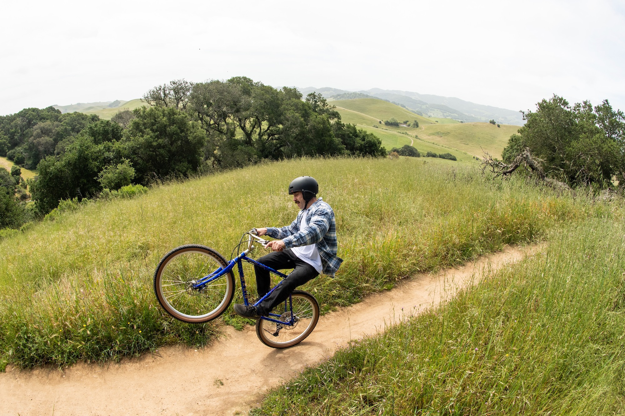 a guy riding a wheelie on the Madrone Trail 40th Anniversary Edition bike.