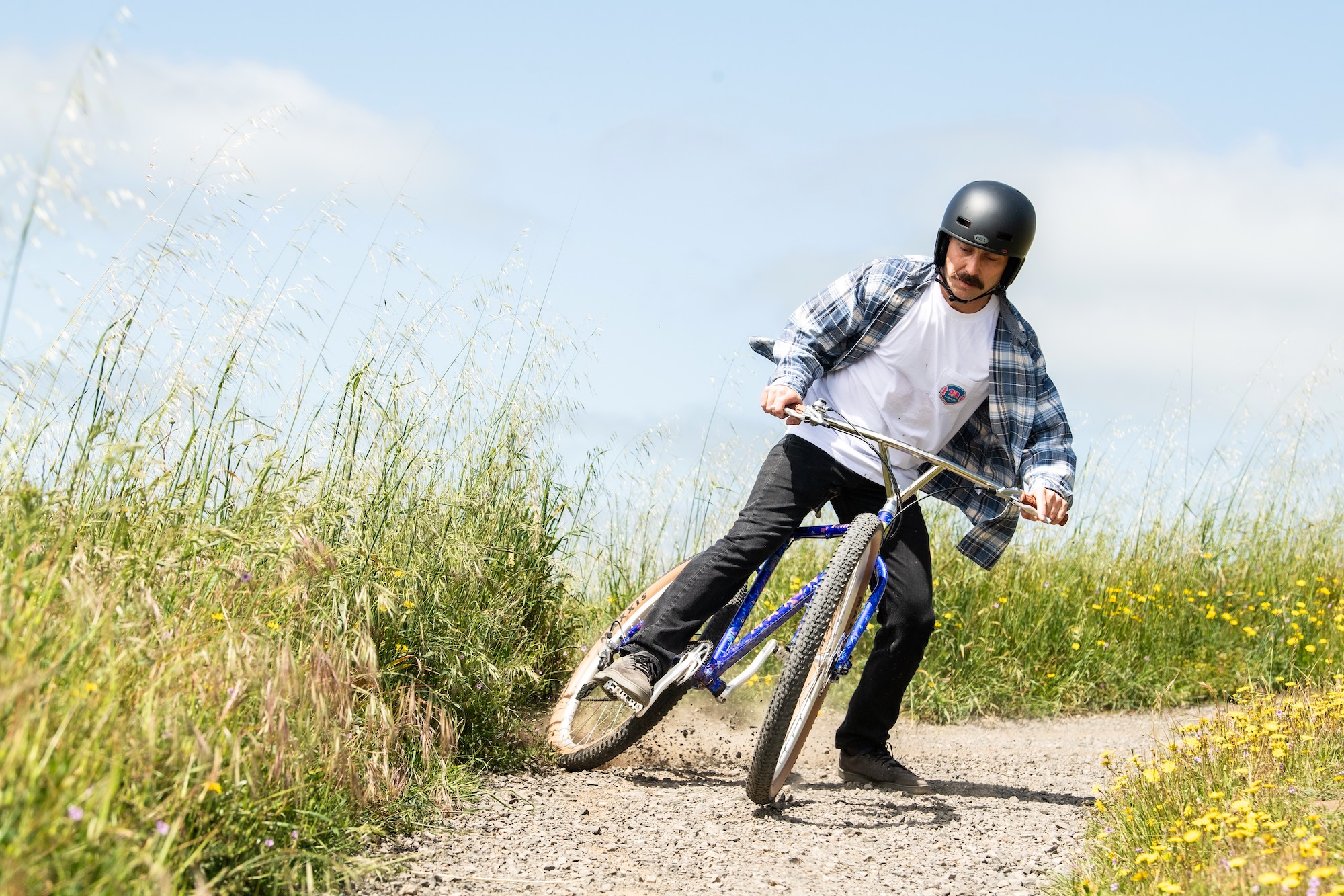 a man riding the Madrone Trail around a flat corner and drifting the rear tire.