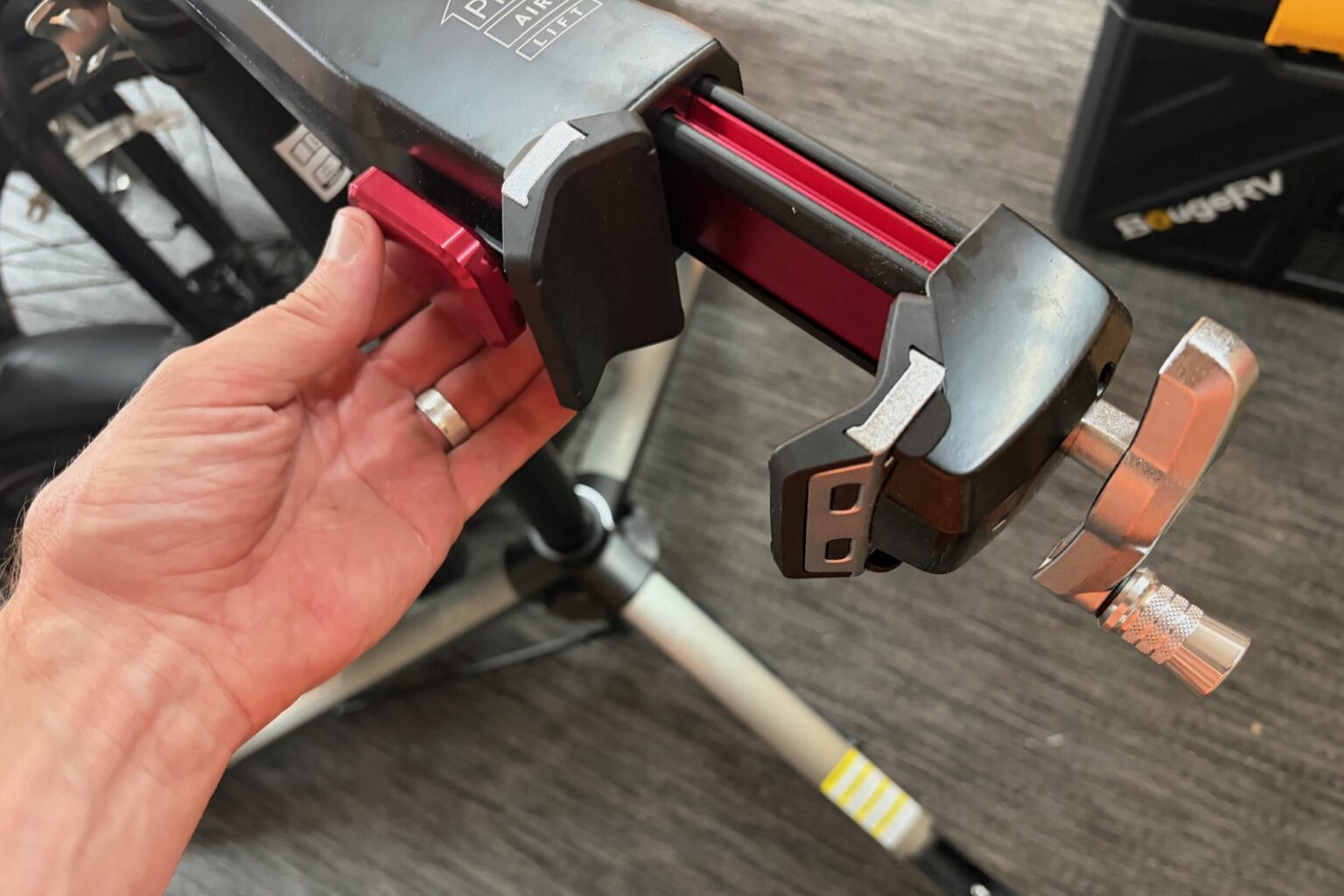 Pressing the Quick-Release button to open the jaws of the Pro Air Lifts Clamp
