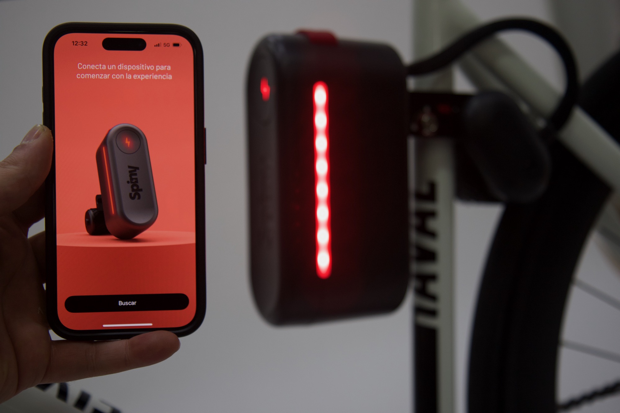 studio image of the Spiny 2 with lights on and a person holding a phone with the Spiny app open