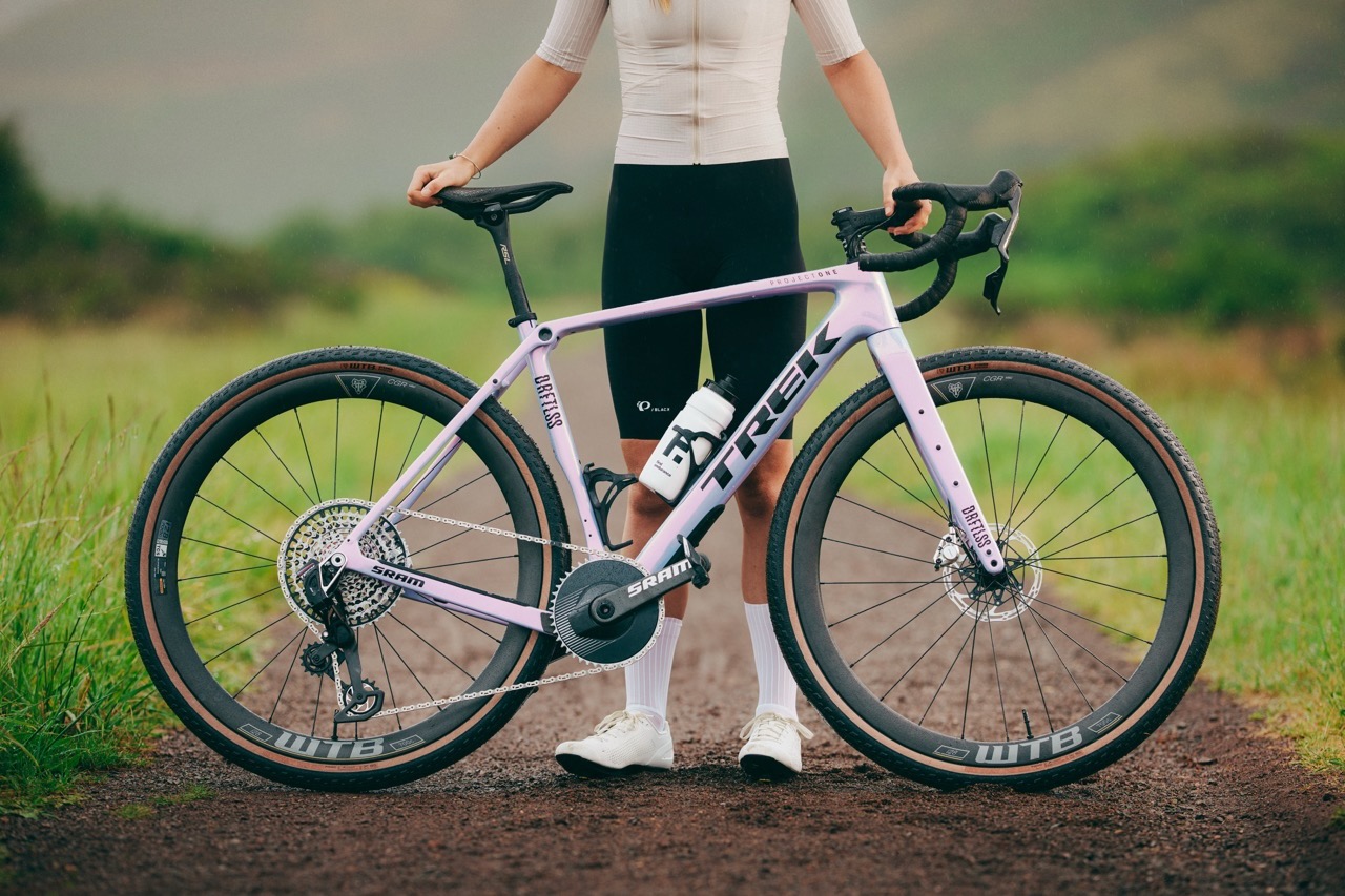 a woman standing next to her bike that has WTB CGR i28 wheels mounted on it.