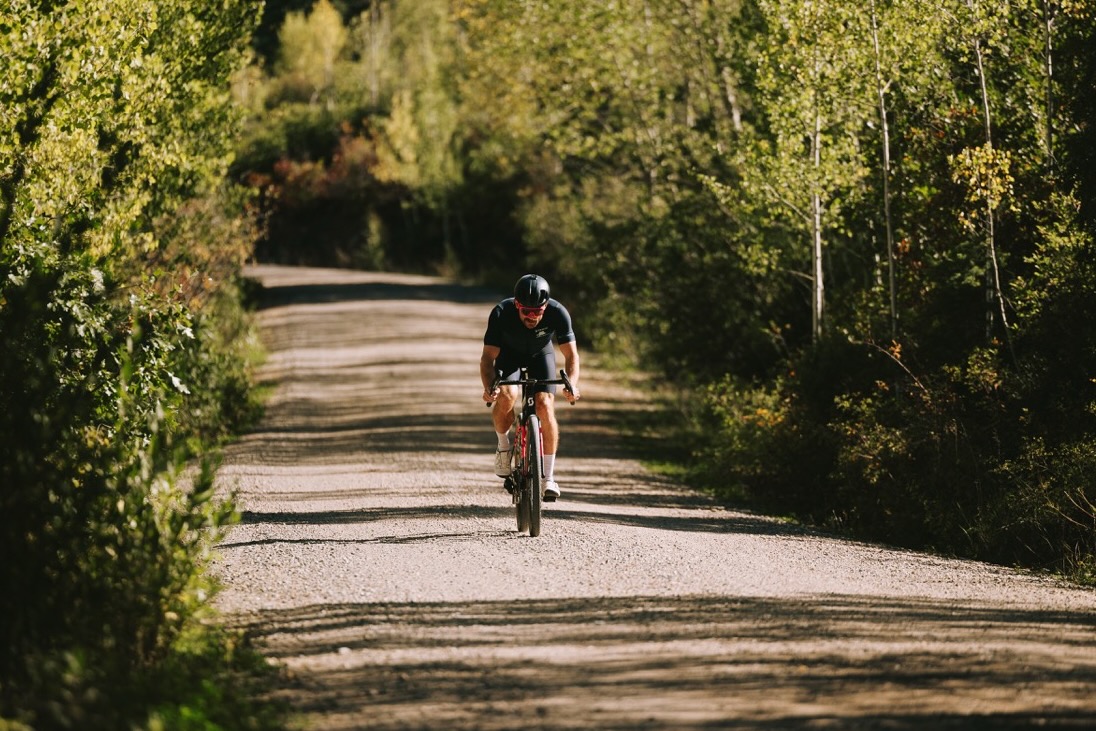 a man riding down a gravel road on a bike with the WTB CGR i28 wheels