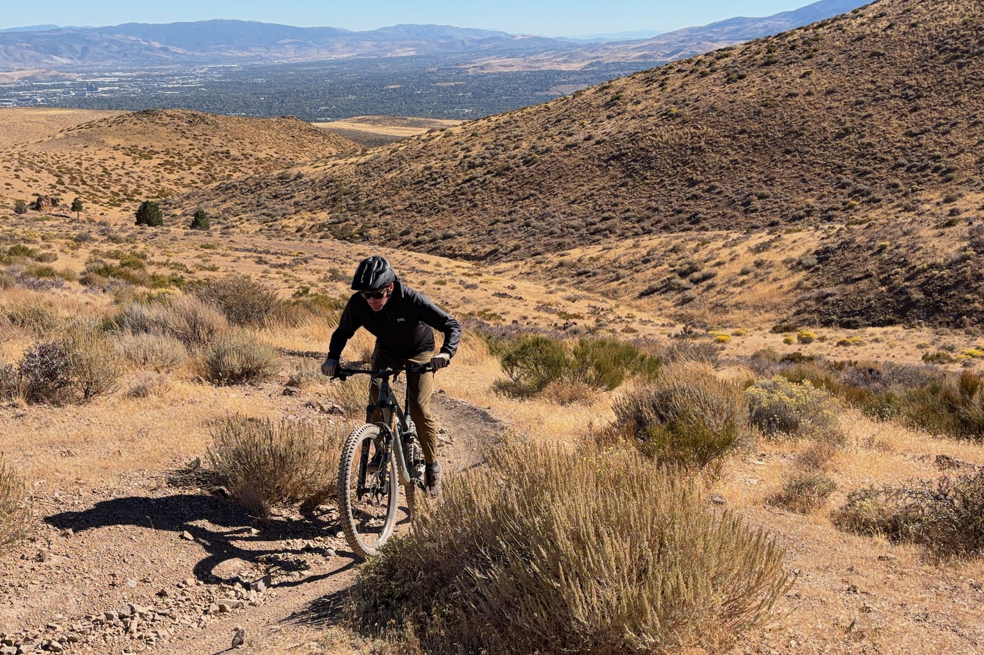 riding around an uphill turn while wearing the Mons Royale Diversion pants and jacket