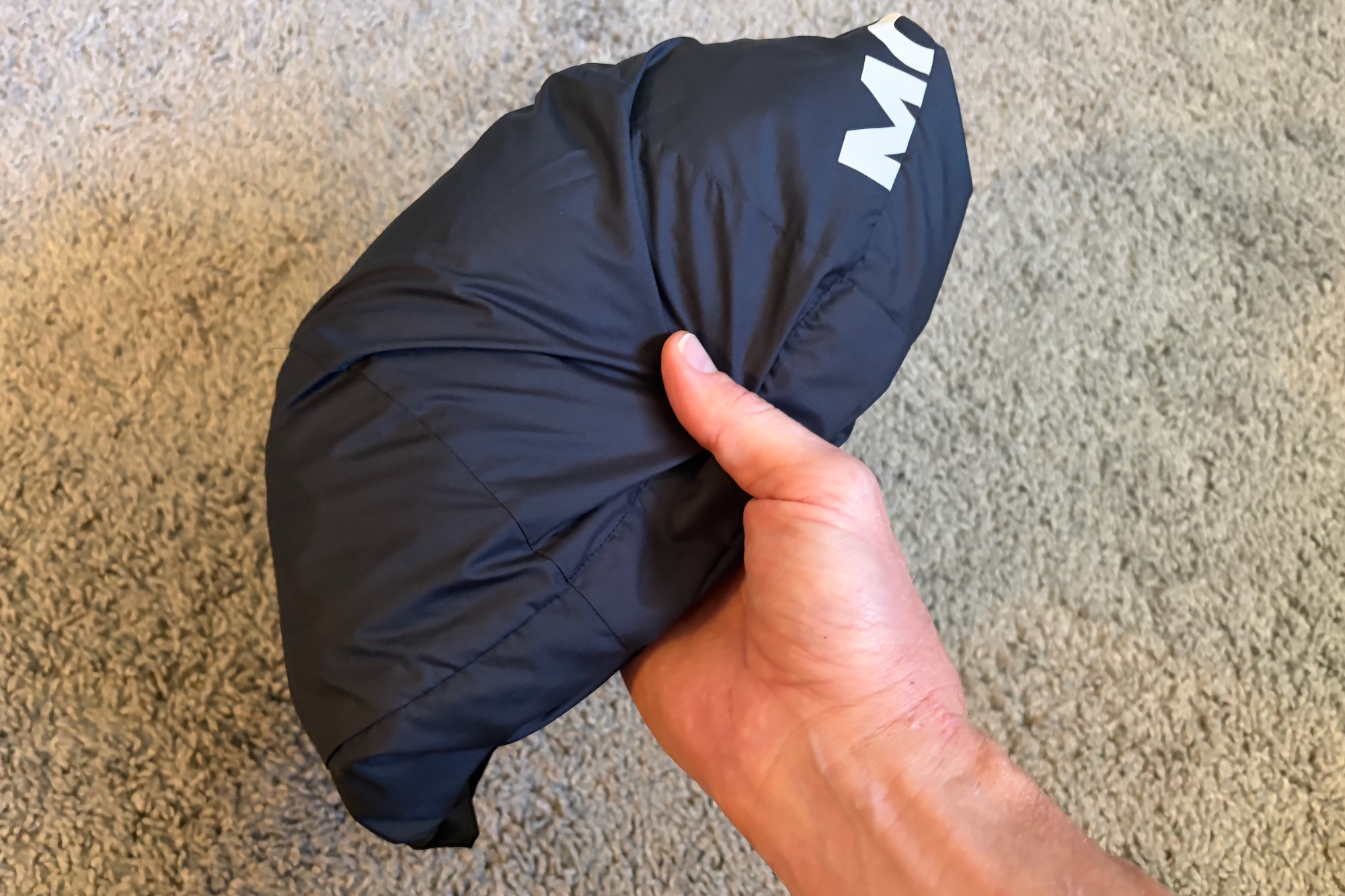 holding the folded Diversion Merino Wind Jacket