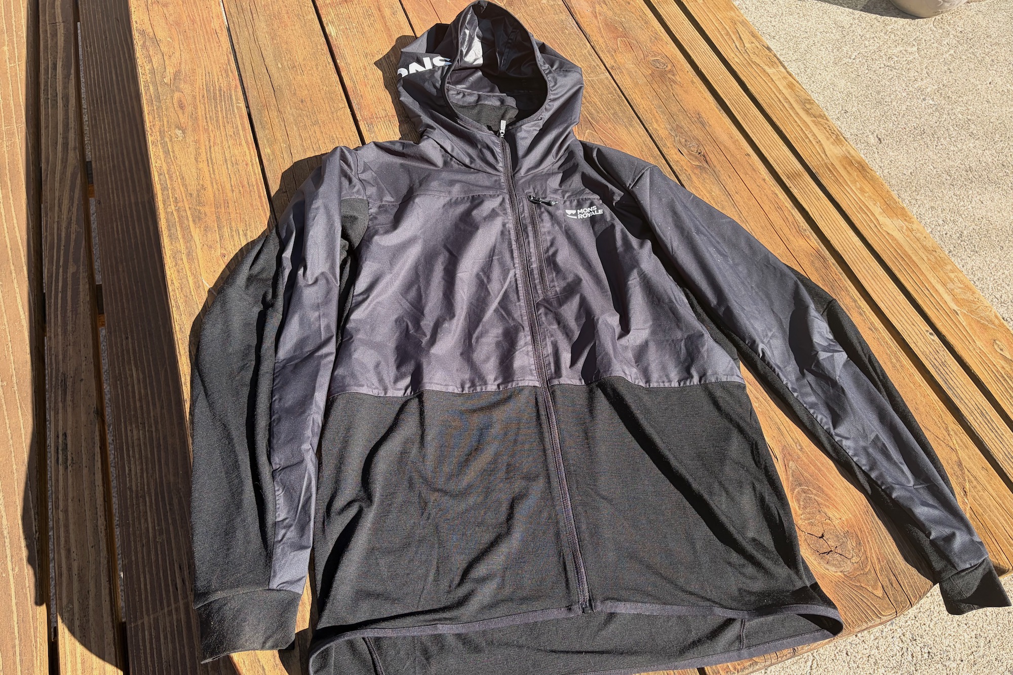 the Mons Royale Diversion Merino Wind Jacket laid on a table